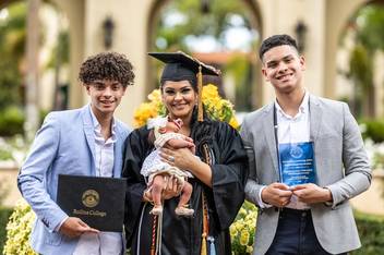 Daniebeth Martinez Negron ’23 celebrates her graduation from Rollins with her two teenage sons and brand-new baby girl.