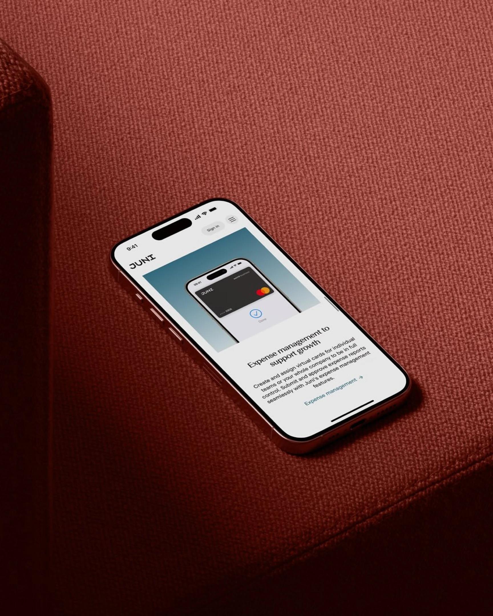 Smartphone displaying Juni brand on red surface
