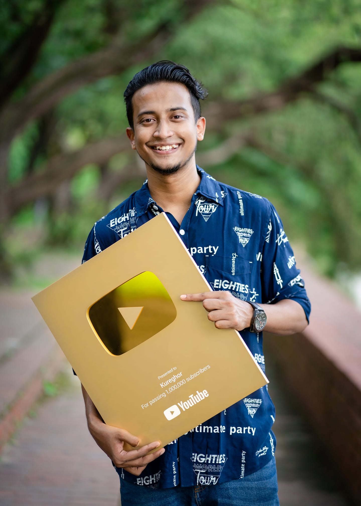 Holding the gold play button presented to Kureghor for passing 1,000,000 subscribers.