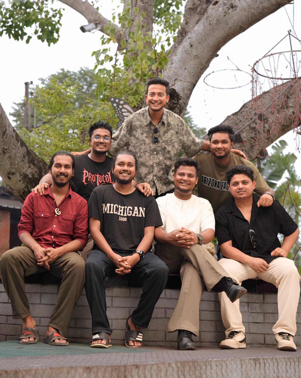 Tasrif Khan with the members of Kureghor, outdoors under a tree.