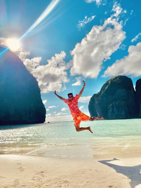 Jumping on a beach between limestone cliffs, Thailand.