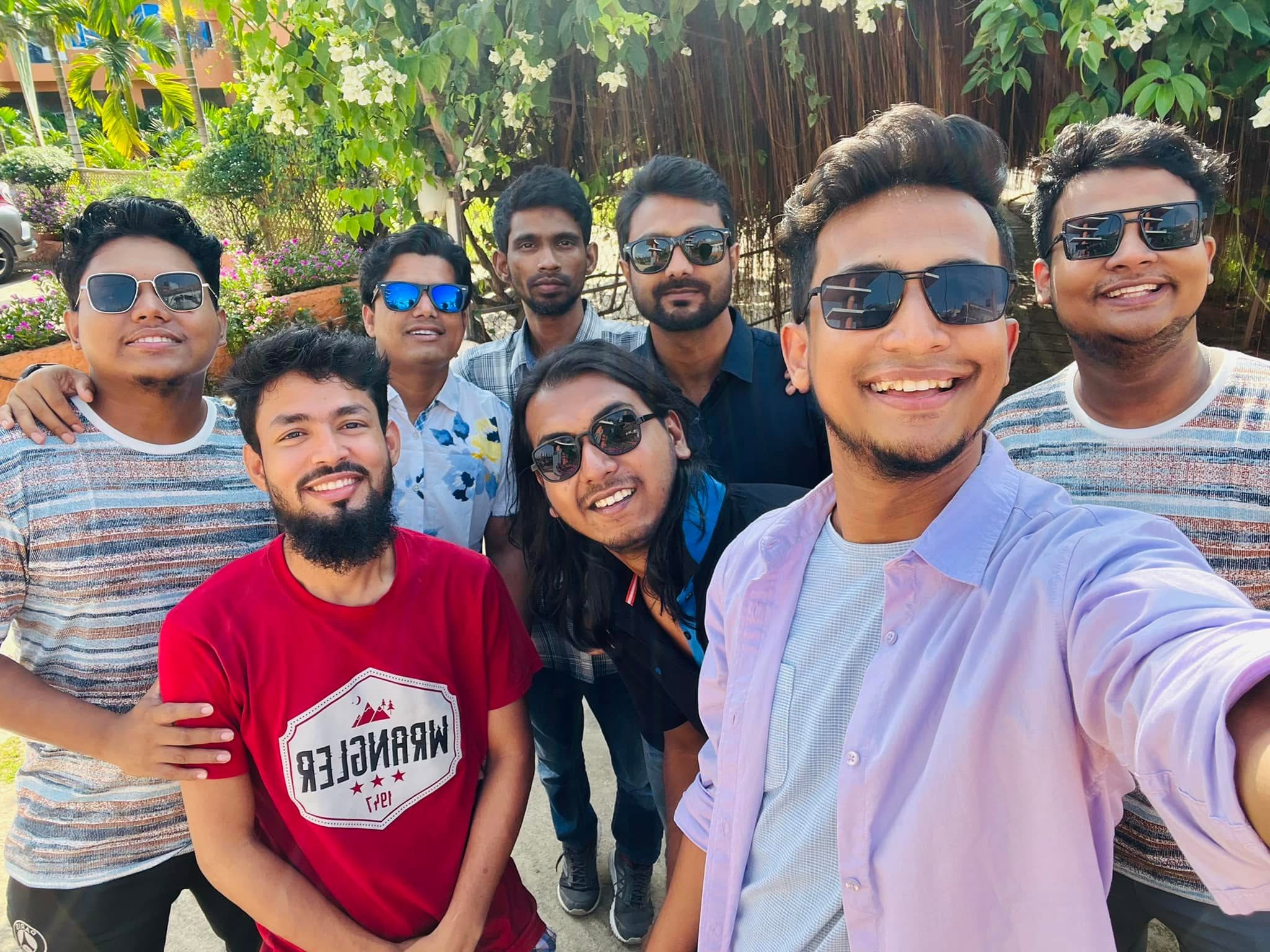 A Kureghor selfie under flowering trees, most of them in sunglasses.