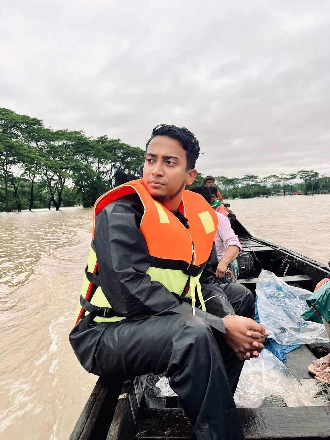 Tasrif in a life jacket, travelling by boat through flood water.