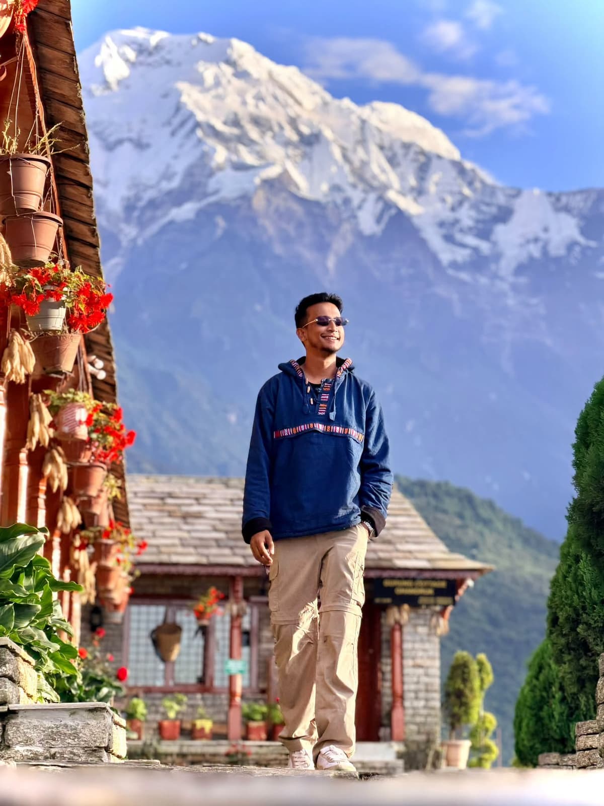 Tasrif standing outdoors with a mountain rising behind him.