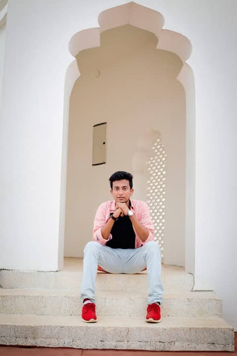 Sitting in a white arched doorway, India.
