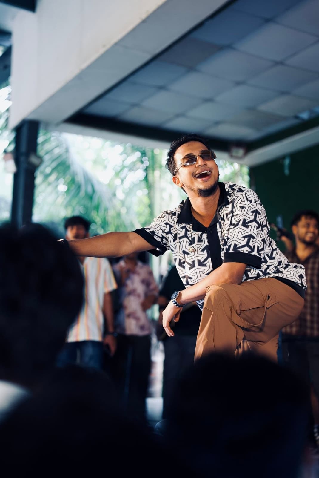 Tasrif Khan mid-song on stage with the band behind him.