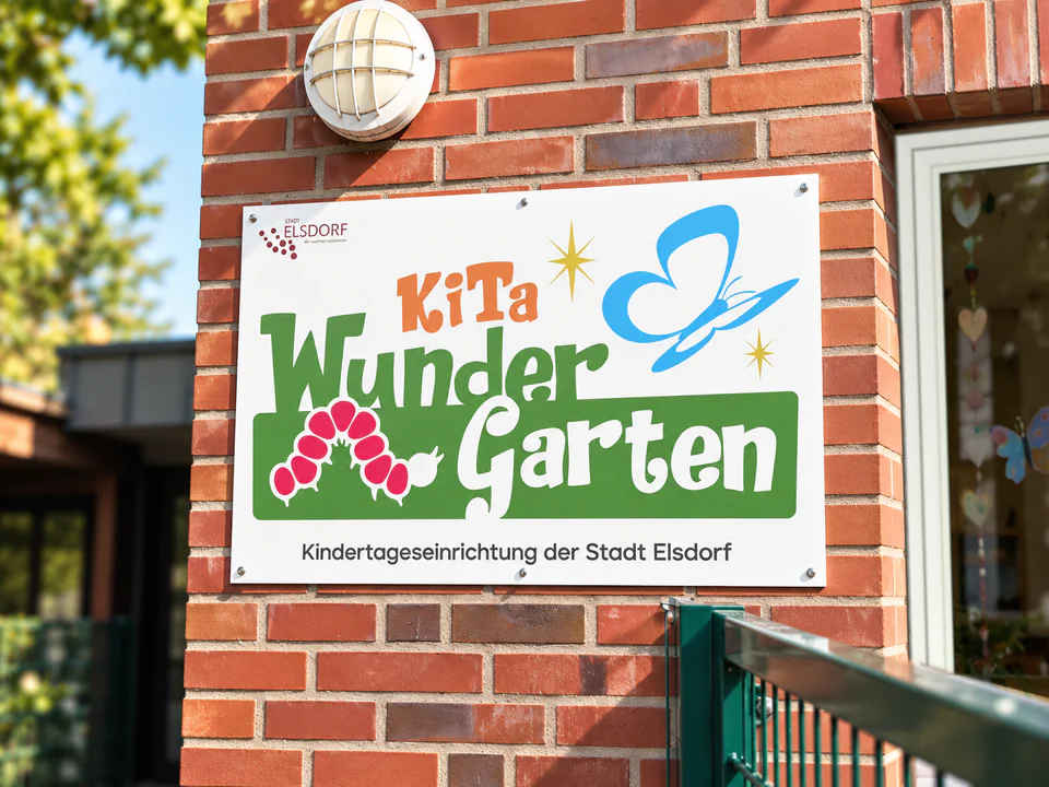 Fassadenschild der Kita Wundergarten in Elsdorf-Oberembt mit dem entwickelten Logo, Raupe und Schmetterling