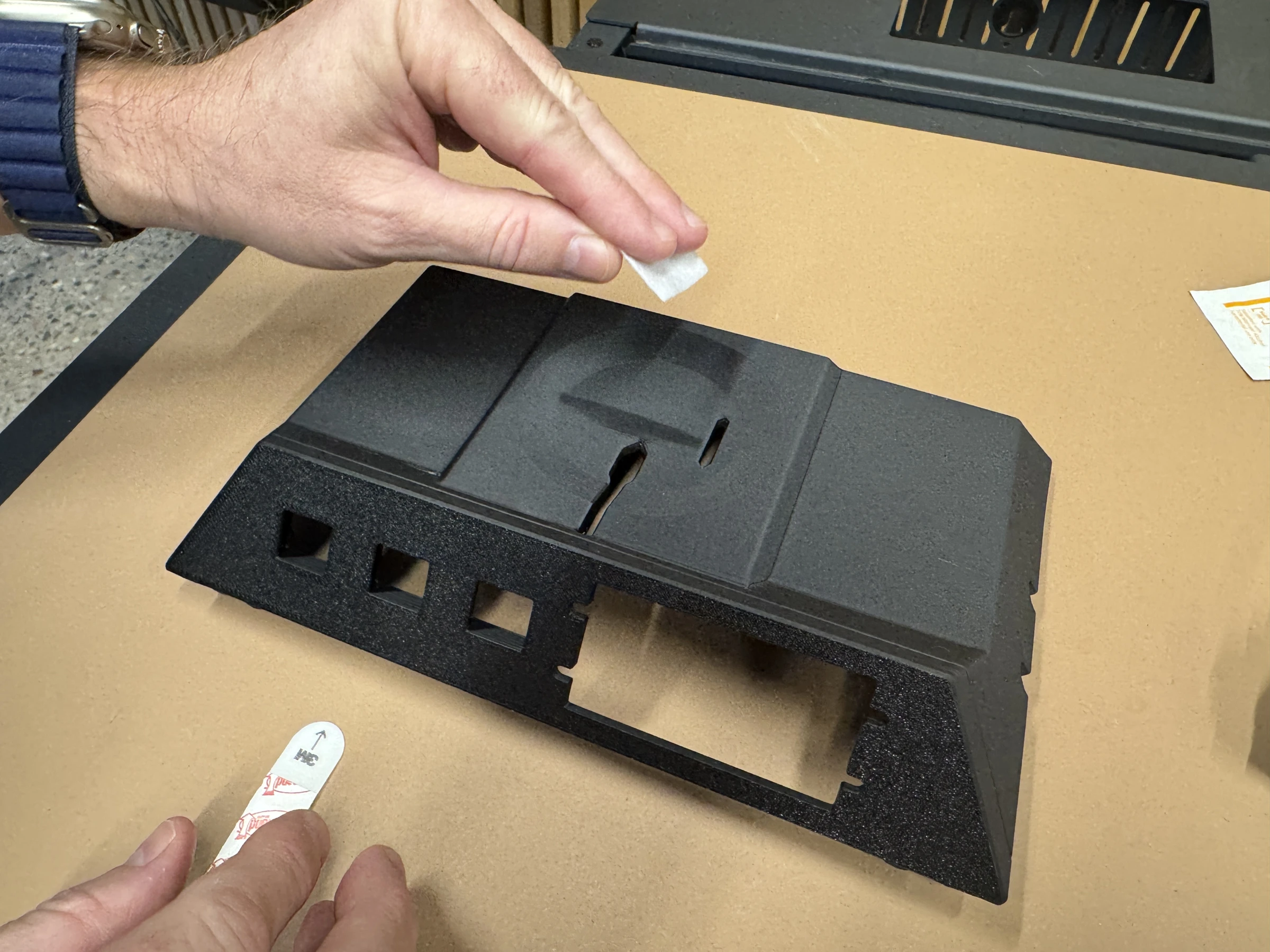 Photograph 3. Wiping the recessed mounting surface; the charging-cable opening is visible beside it.