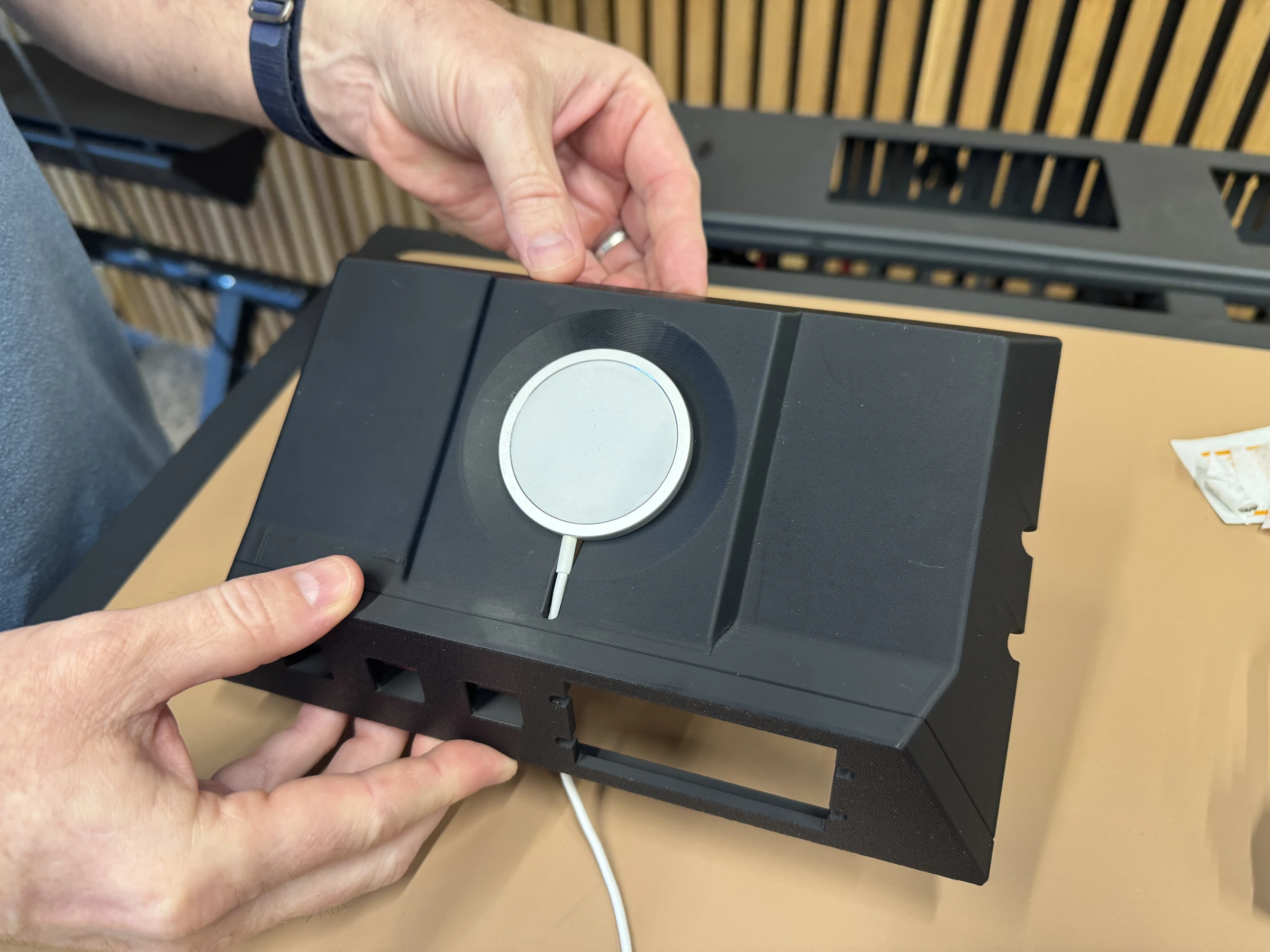 Photograph 11. The charging puck seated in the insert, with its cable routed through the opening.