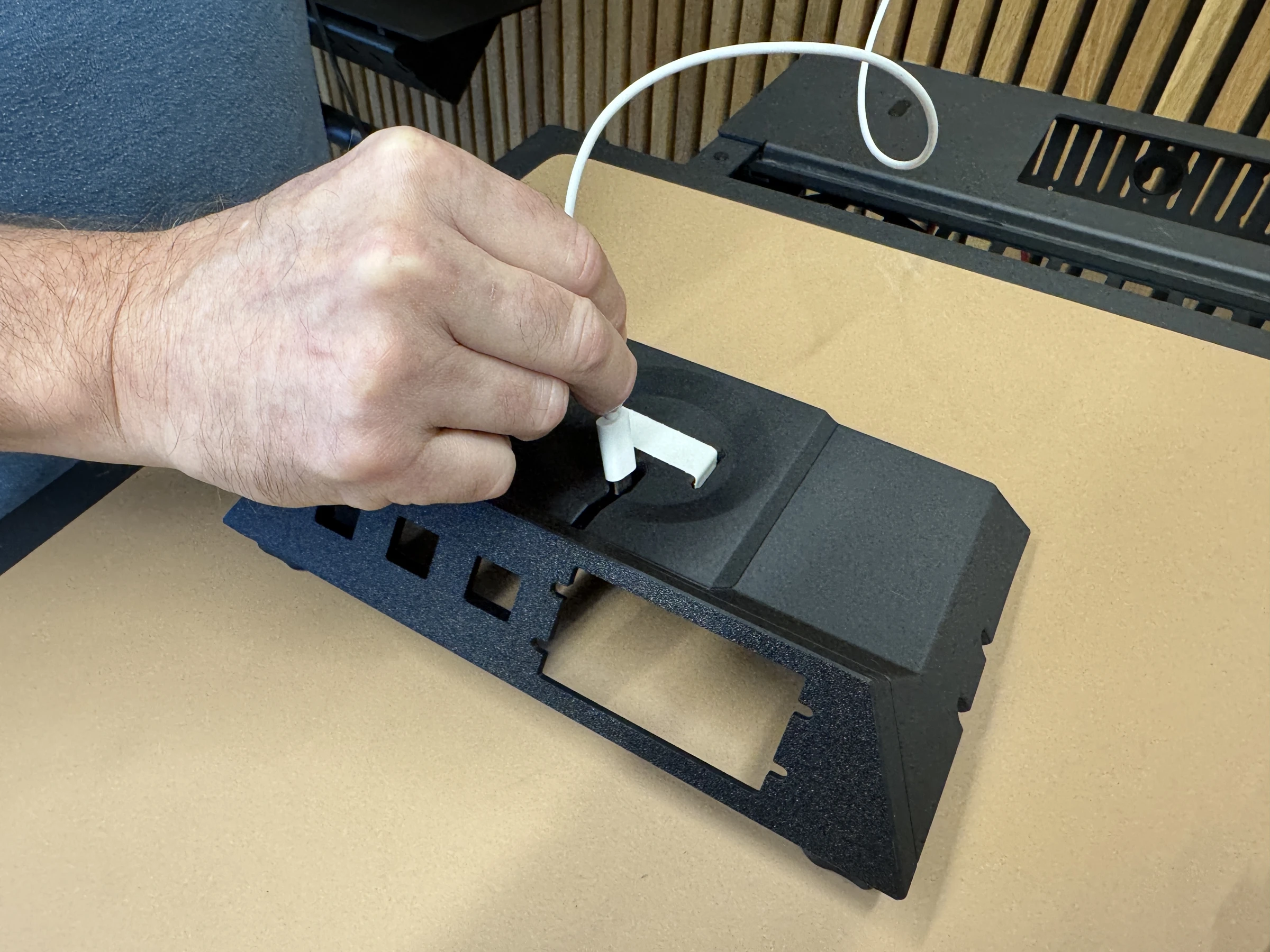 Photograph 8. Routing the charging puck cable through the opening in the insert.