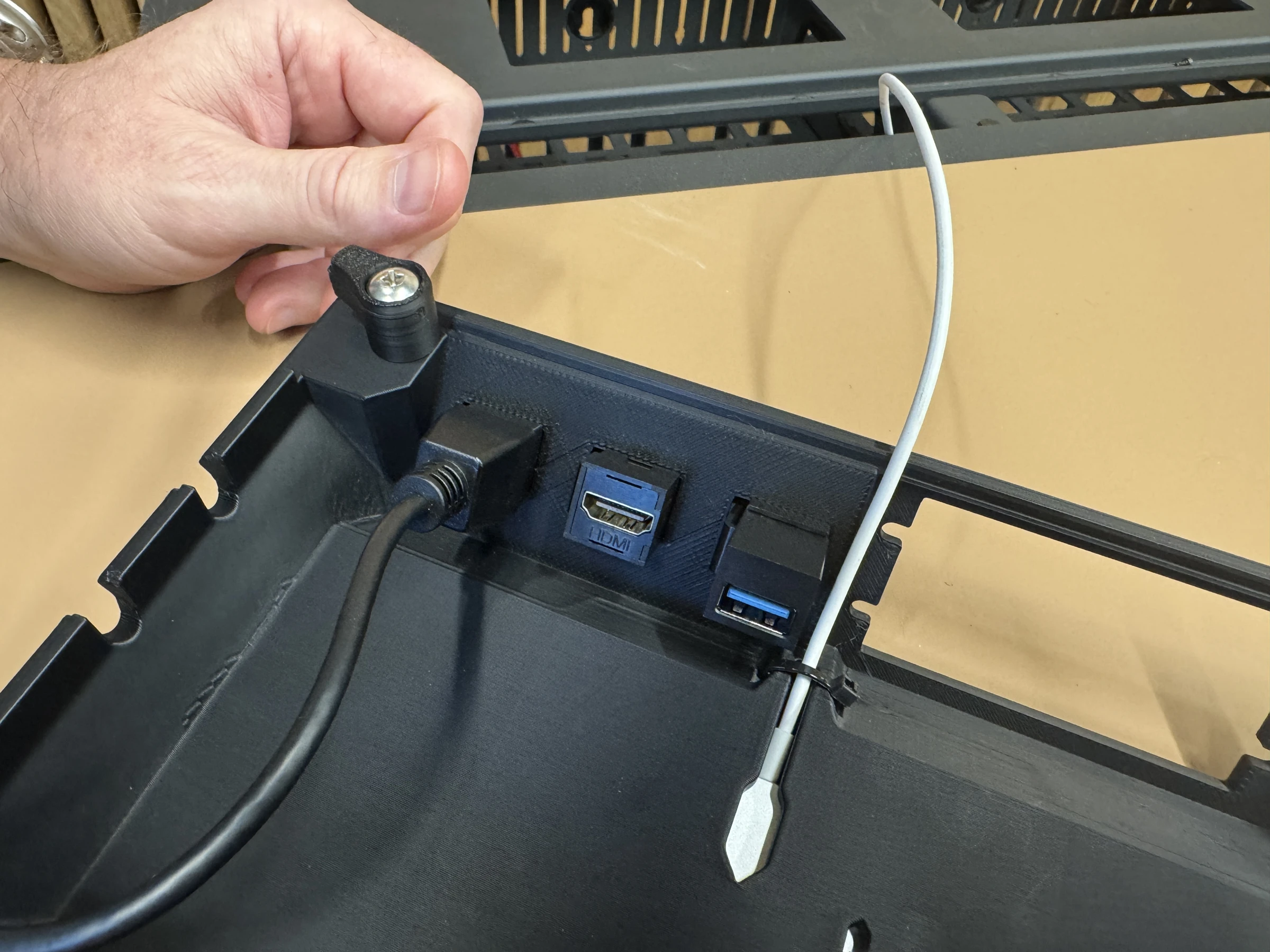 Photograph 20. Underside view of the populated keystone openings and attached cables, beside the white charging cable.