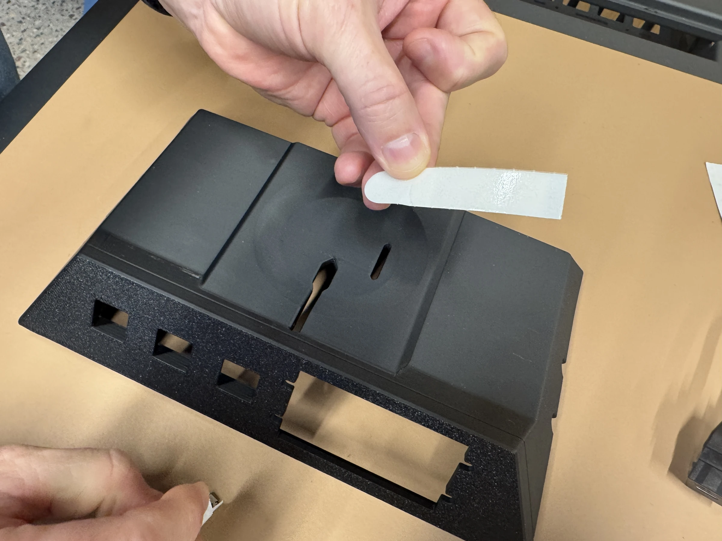 Photograph 5. Positioning the adhesive strip above the recessed mounting surface.