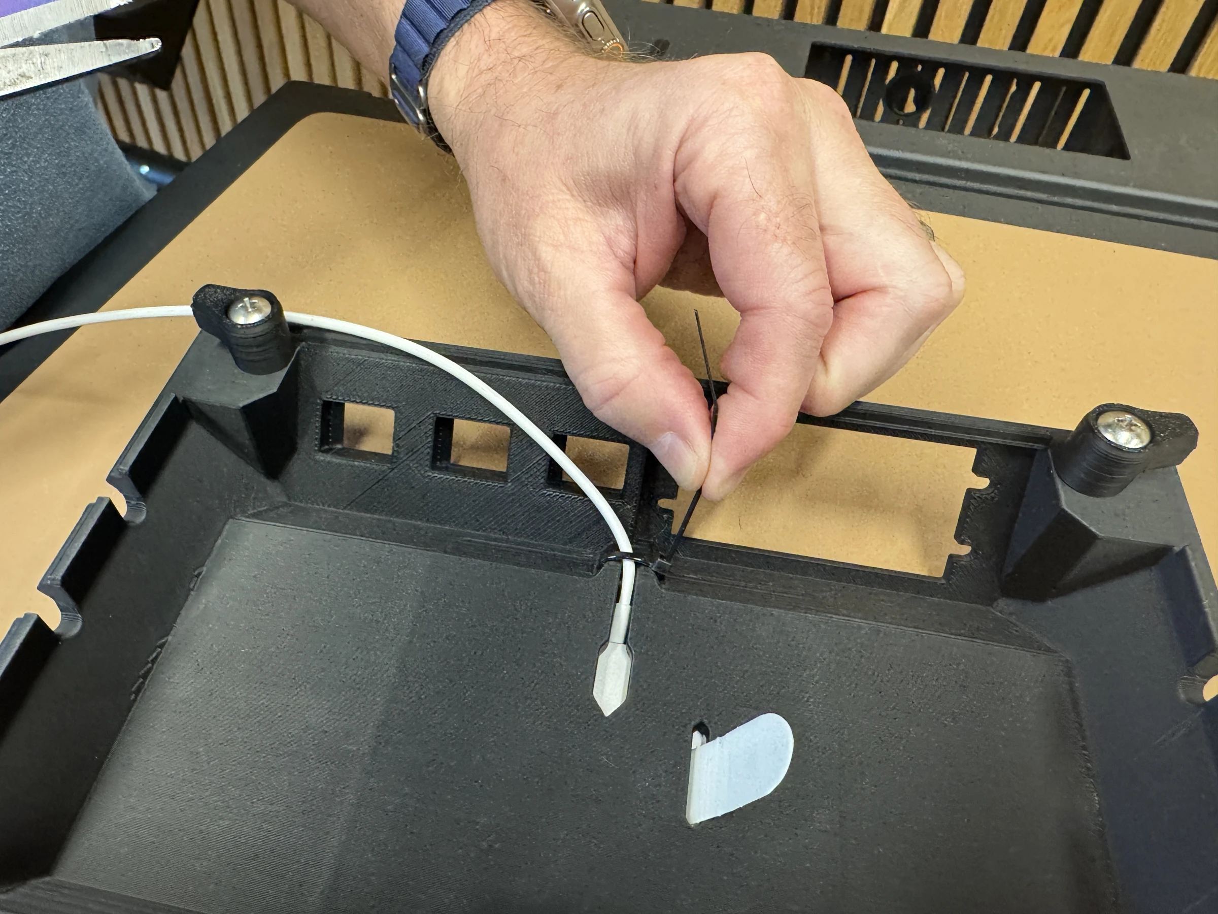Photograph 14. Fastening the cable to the underside with a cable tie.