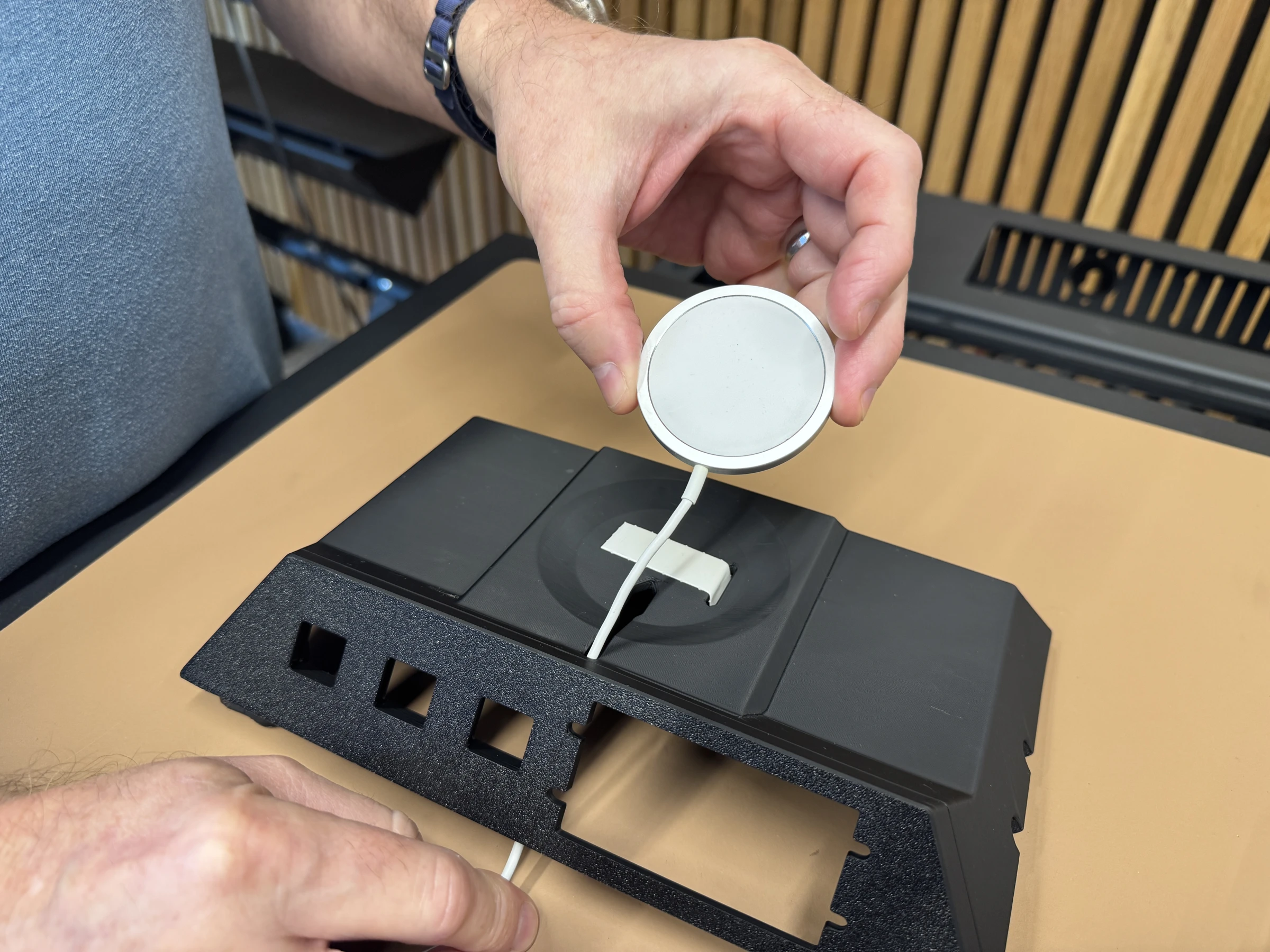 Photograph 9. Holding the charging puck over the prepared mounting area.