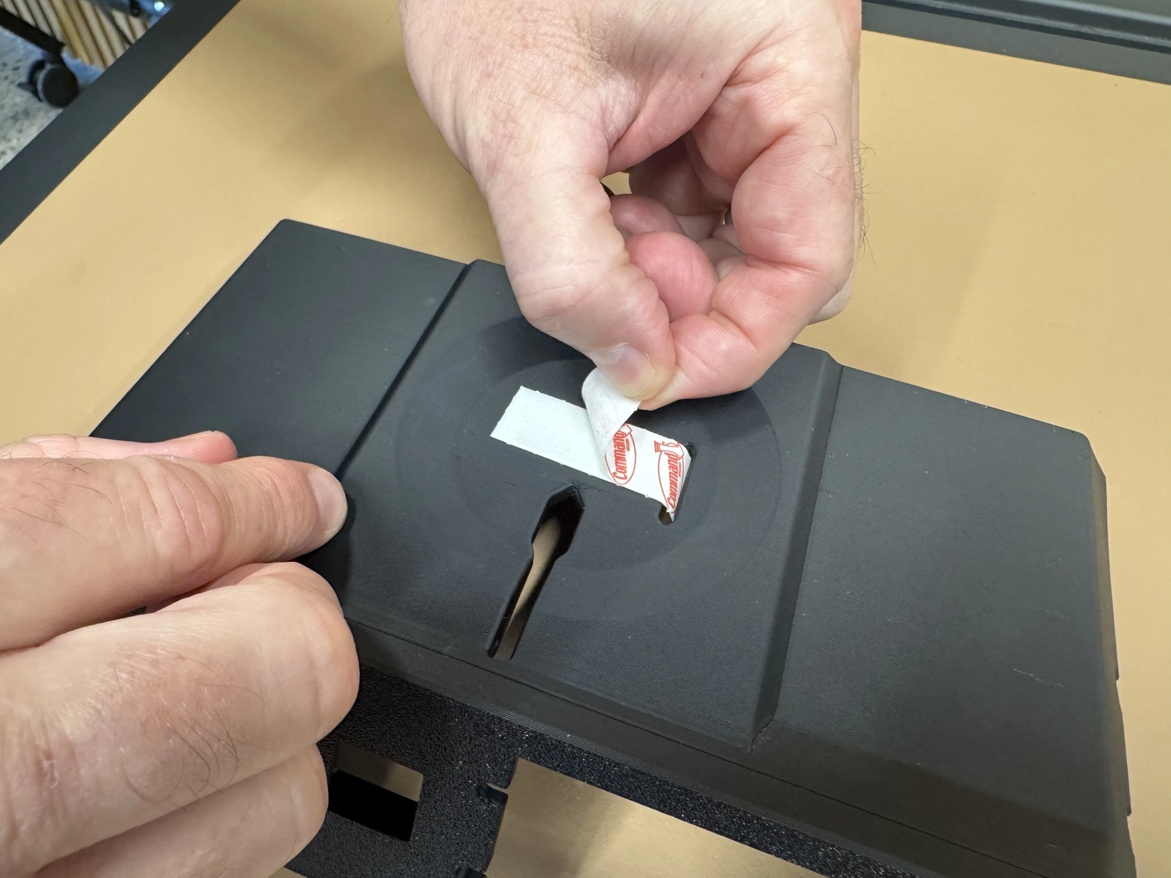 Photograph 7. Peeling the protective liner from the adhesive strip.