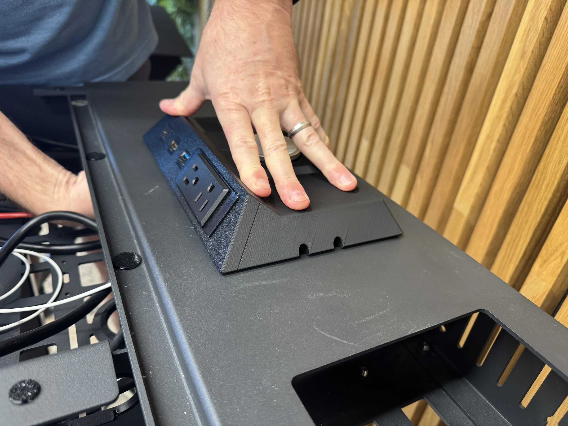 Photograph 34. Holding the insert down with one hand while reaching beneath the desktop with the other; the retaining mechanism is obscured.