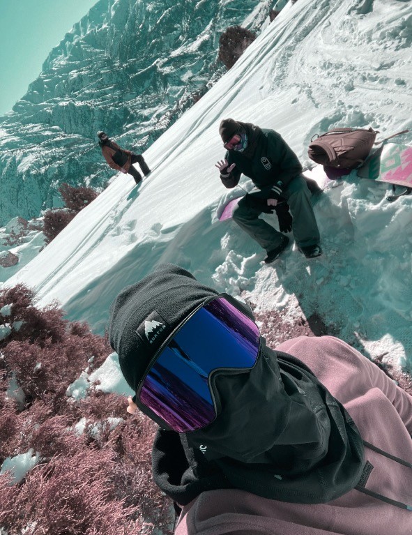 Snowboarders taking a break on a snowy mountain slope.