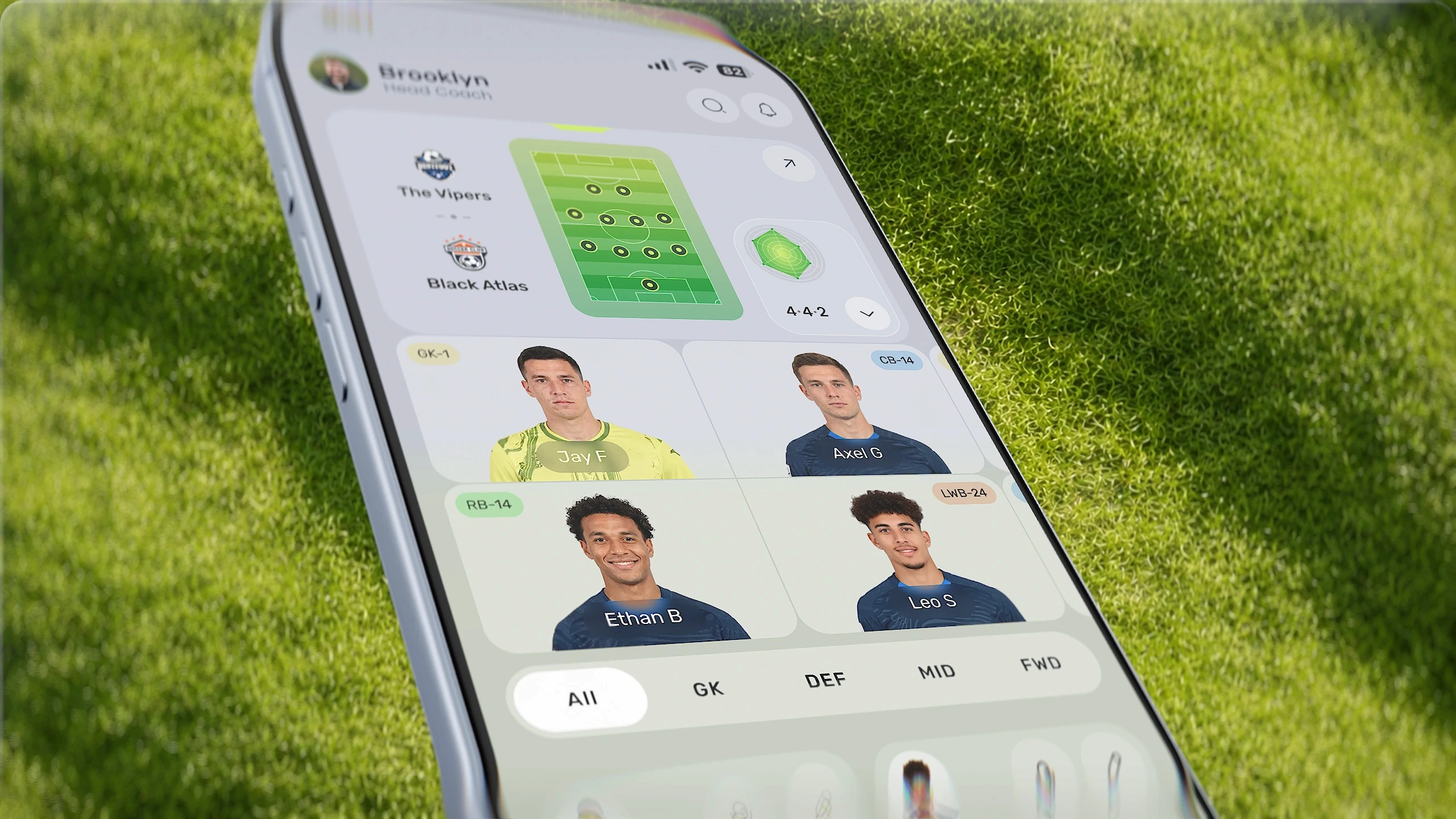 Mobile UI for Pro Scout app, featuring tactical analysis, football field formation, and player cards on a smartphone resting on grass