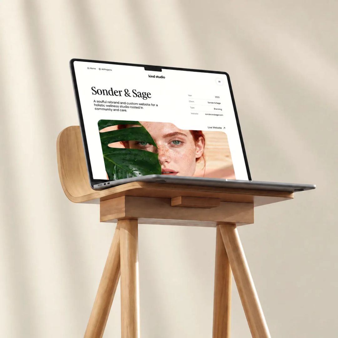 Laptop auf einem Holzständer mit dem Framer-Template Kind Studio