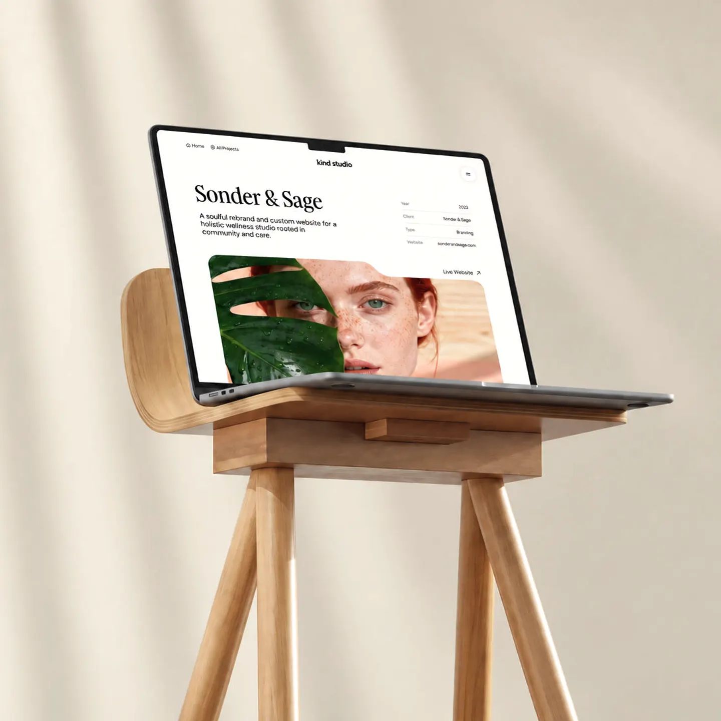 Laptop auf einem Holzständer mit dem Framer-Template Kind Studio