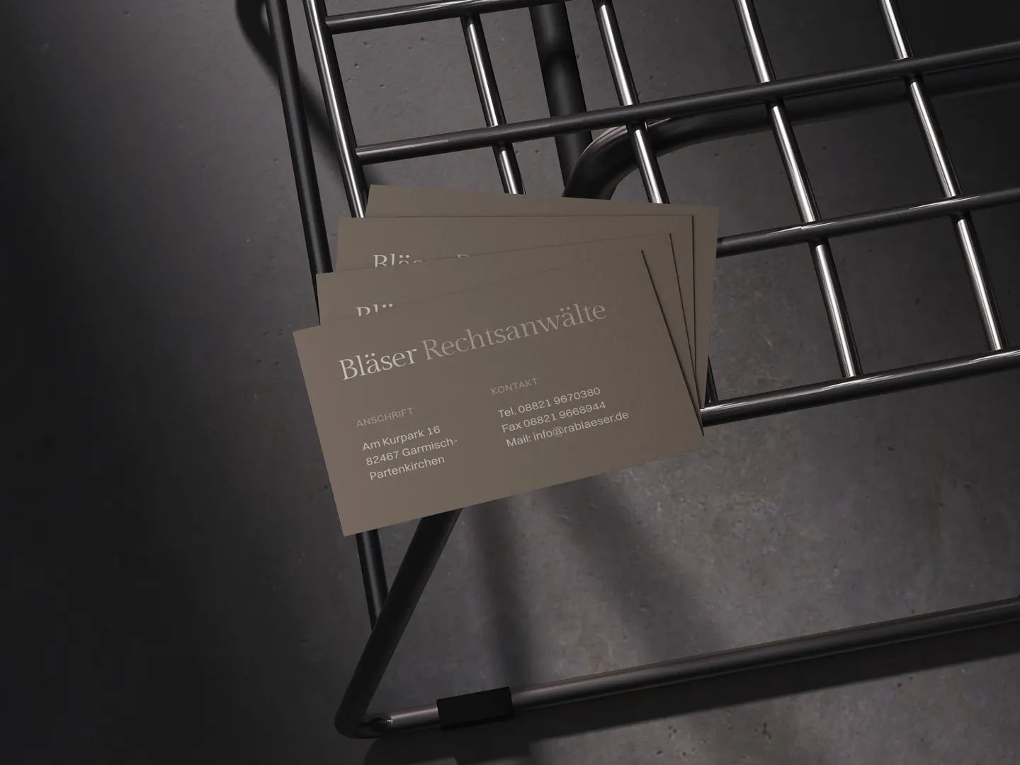 Visitenkarten von Bläser Rechtsanwälte auf einem Metallstuhl