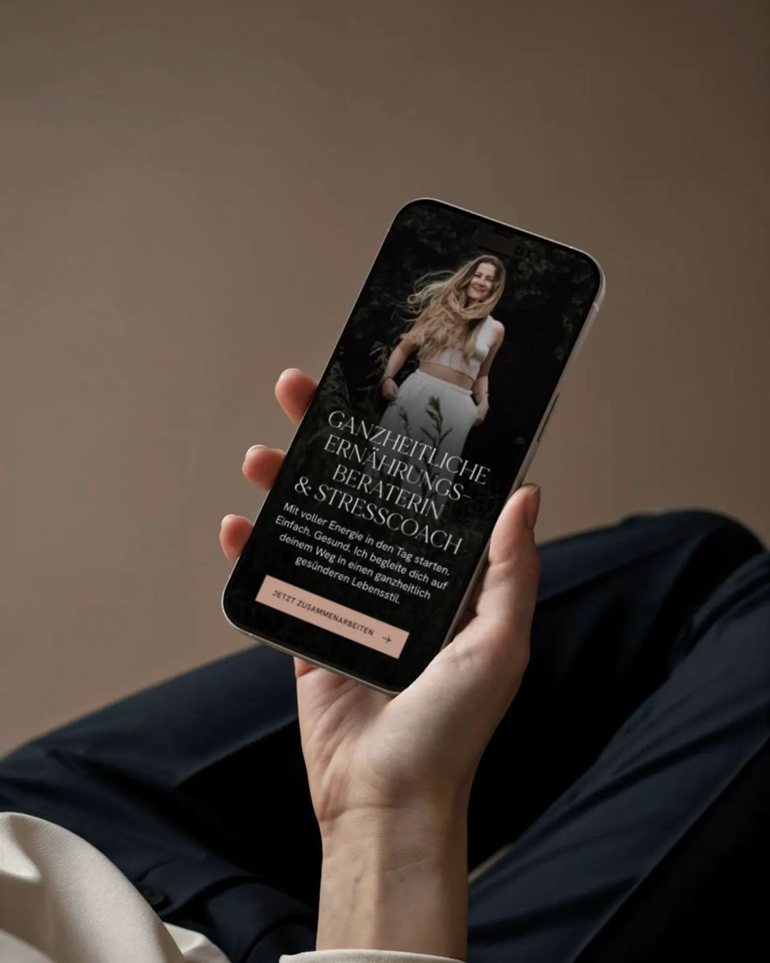 Hand hält ein Smartphone mit der Website von Antonia Bläser