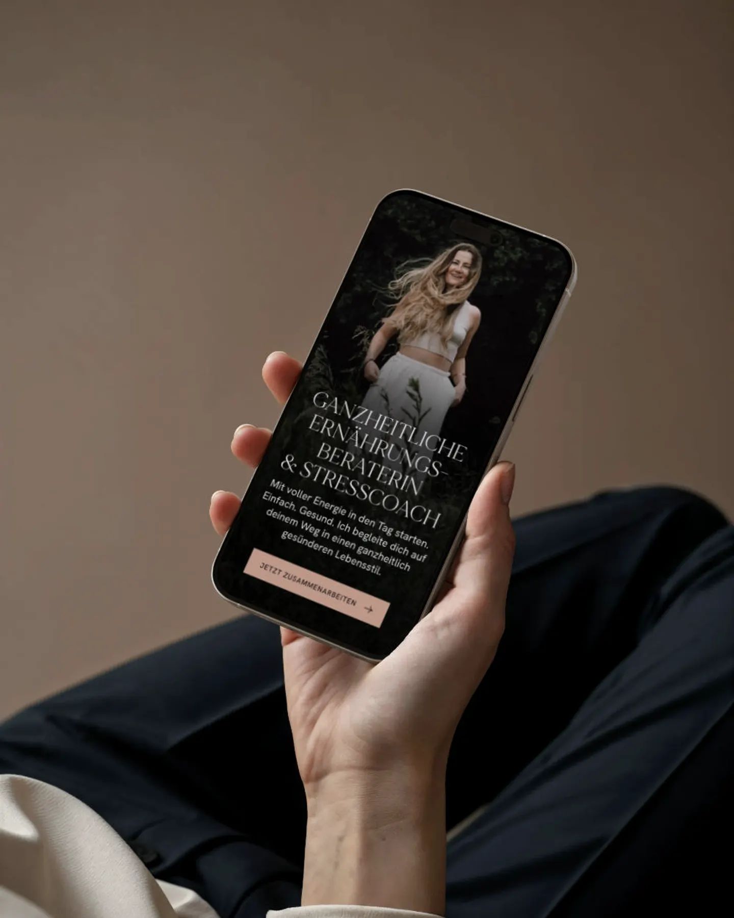 Hand hält ein Smartphone mit der Website von Antonia Bläser