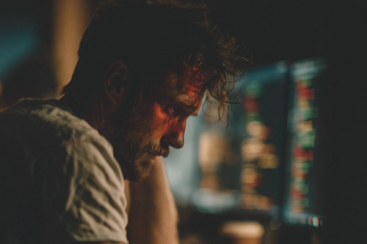 A lone software engineer sitting at a desk in a dark office at 2am.