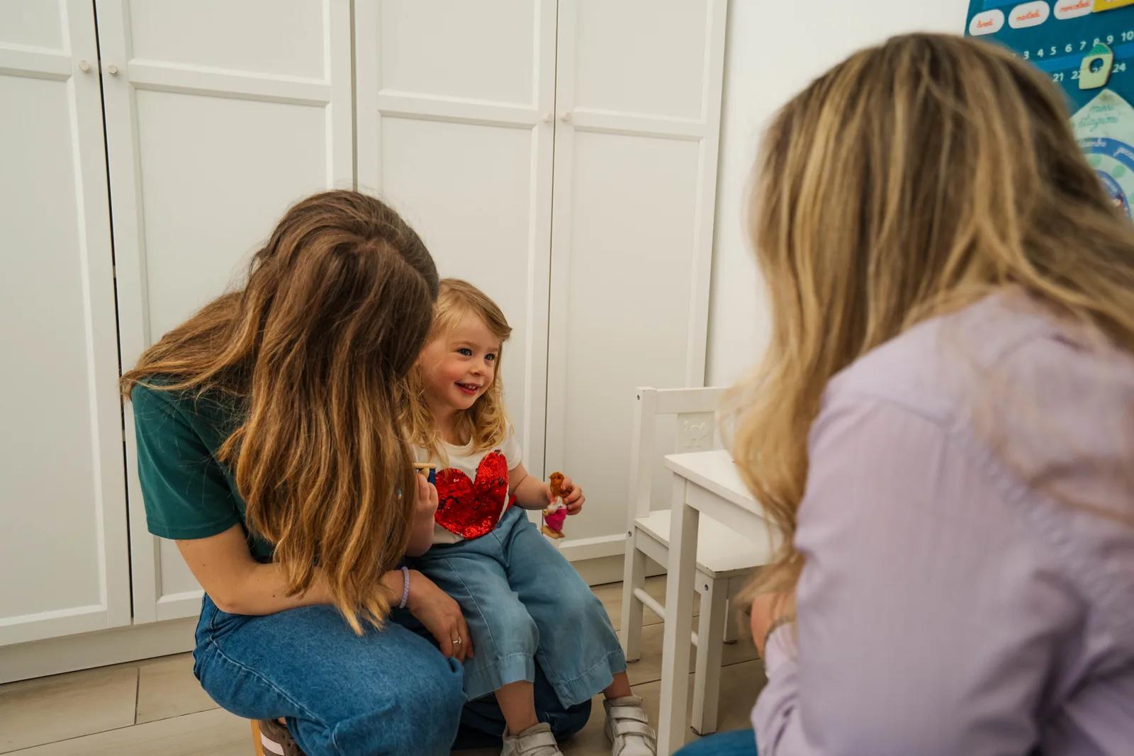 Mariangela Allegrini in seduta di logopedia con una bambina sorridente nello studio a Viterbo