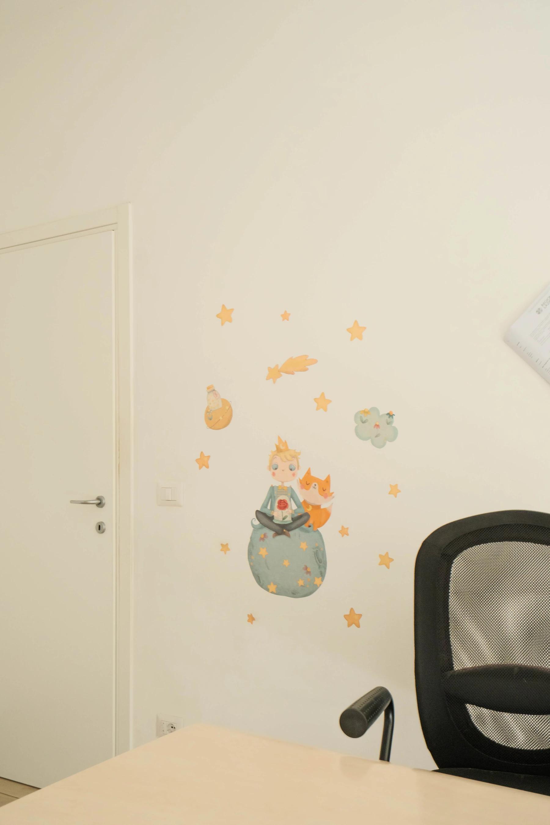 Parete dello studio di logopedia con illustrazione del Piccolo Principe e stelle dorate