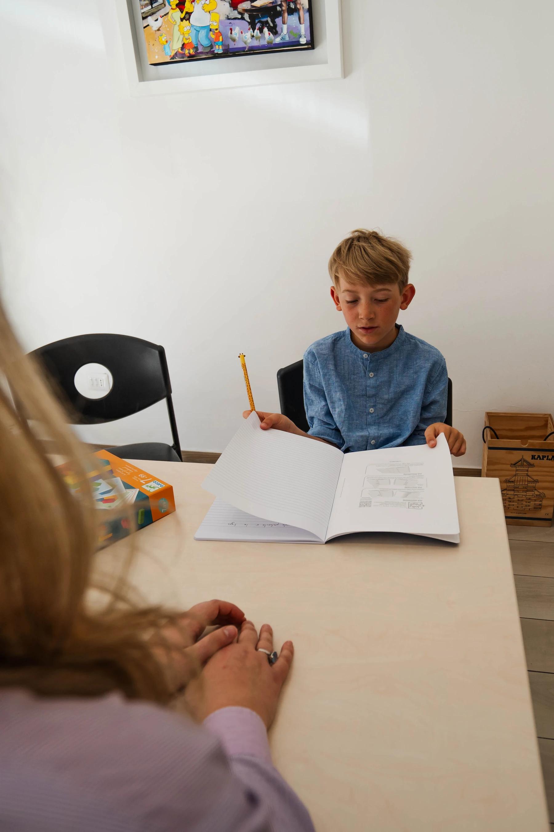 Bambino con quaderno e penna durante un'attività di valutazione, studio di logopedia a Viterbo