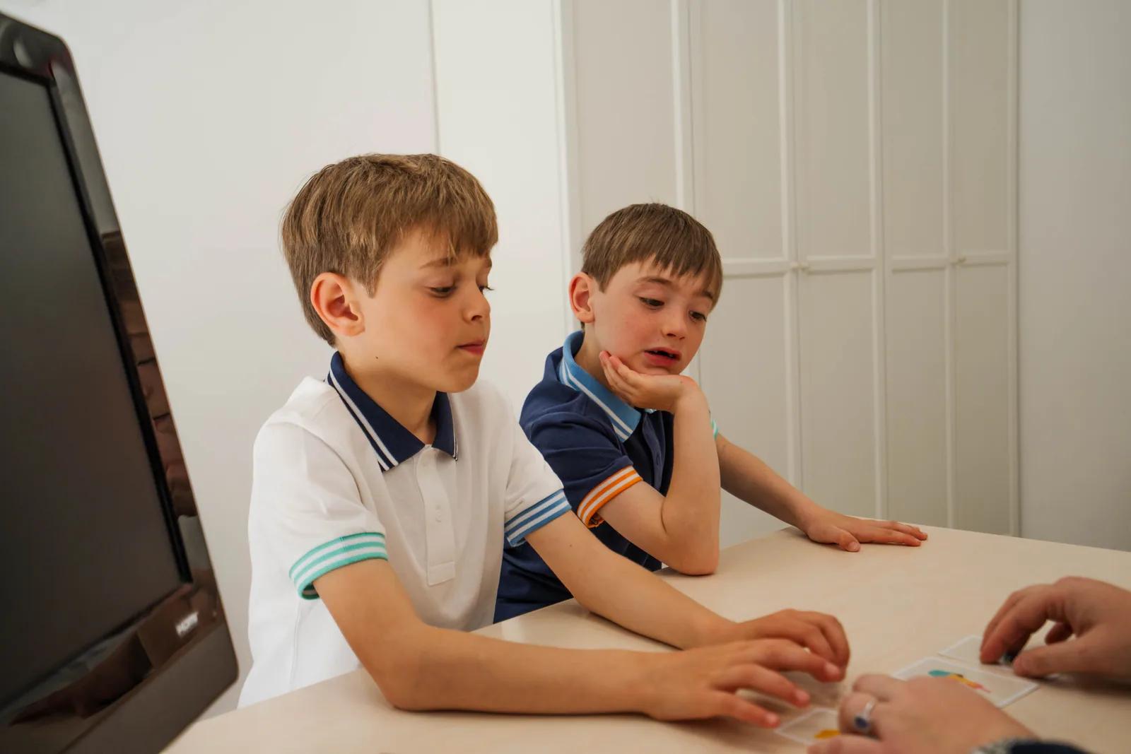 Due bambini concentrati durante un'attività al tavolo, studio di logopedia a Viterbo
