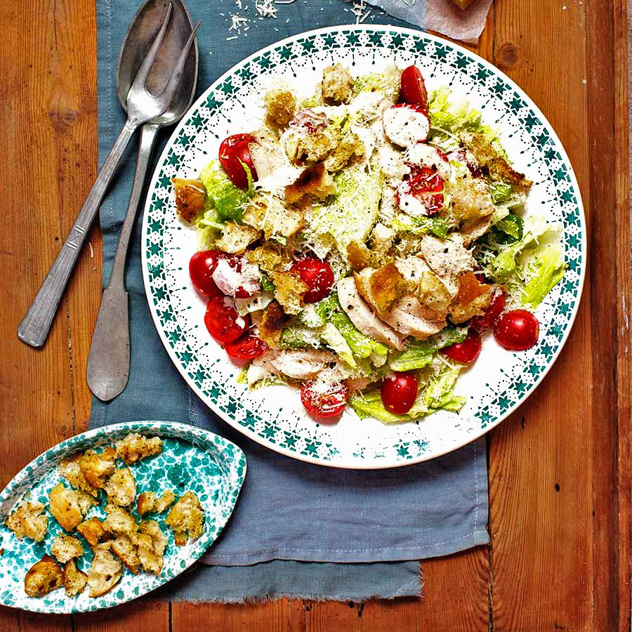 Ceasarsallad och krutonger uppdukade på fat