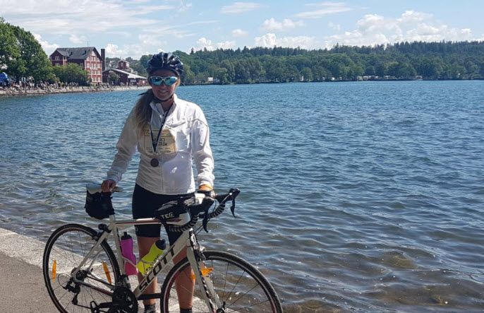 Kvinnlig cyklist med sin cykel på en kaj