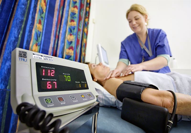 Sköterska och patient på en brits