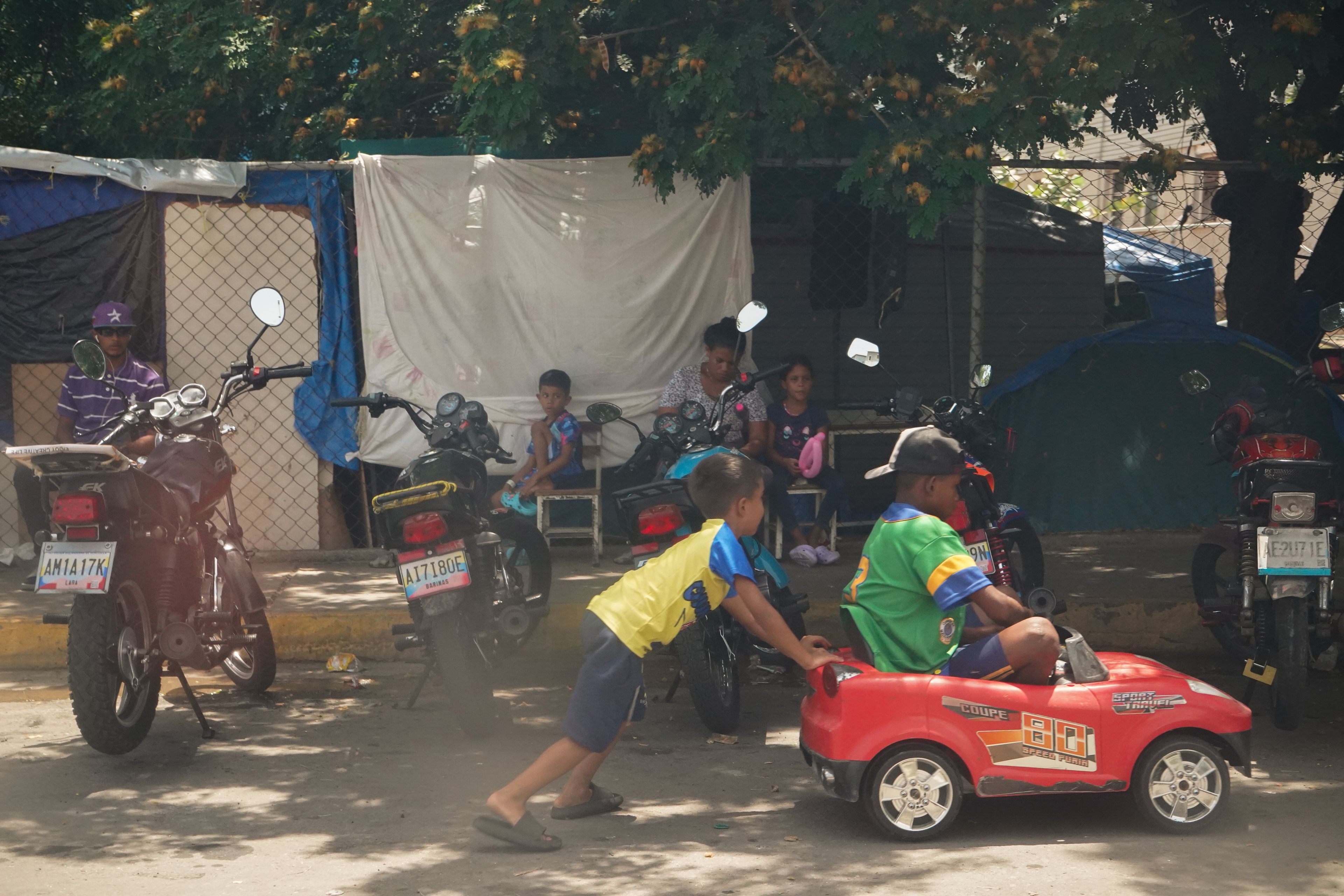 Children play beside parked motorcycles in a Caracas neighbourhood. Photo: María José Dugarte.