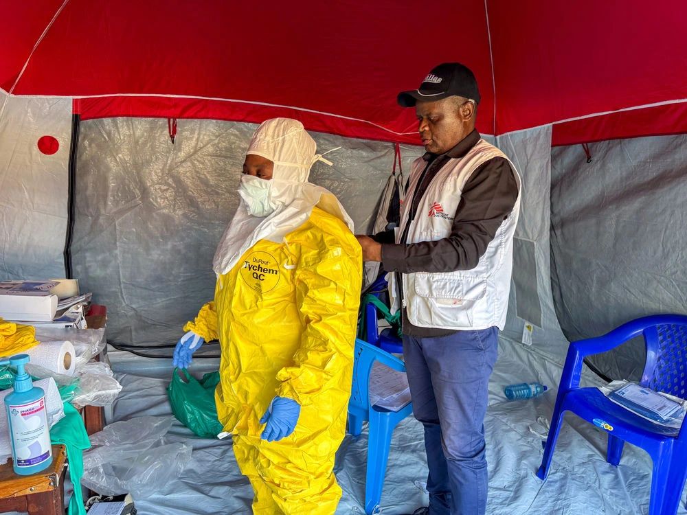 Nurses and doctors are assisted by trained MSF staff as they put on full personal protective equipment (PPE) in a designated area of the Elikya Ebola Treatment Centre in Bunia, Ituri province.