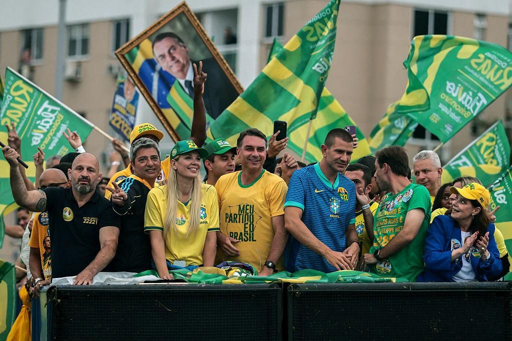 Flávio Bolsonaro campaigns alongside supporters waving Brazilian flags during a rally in Brazil. Photo: Agência Brasil