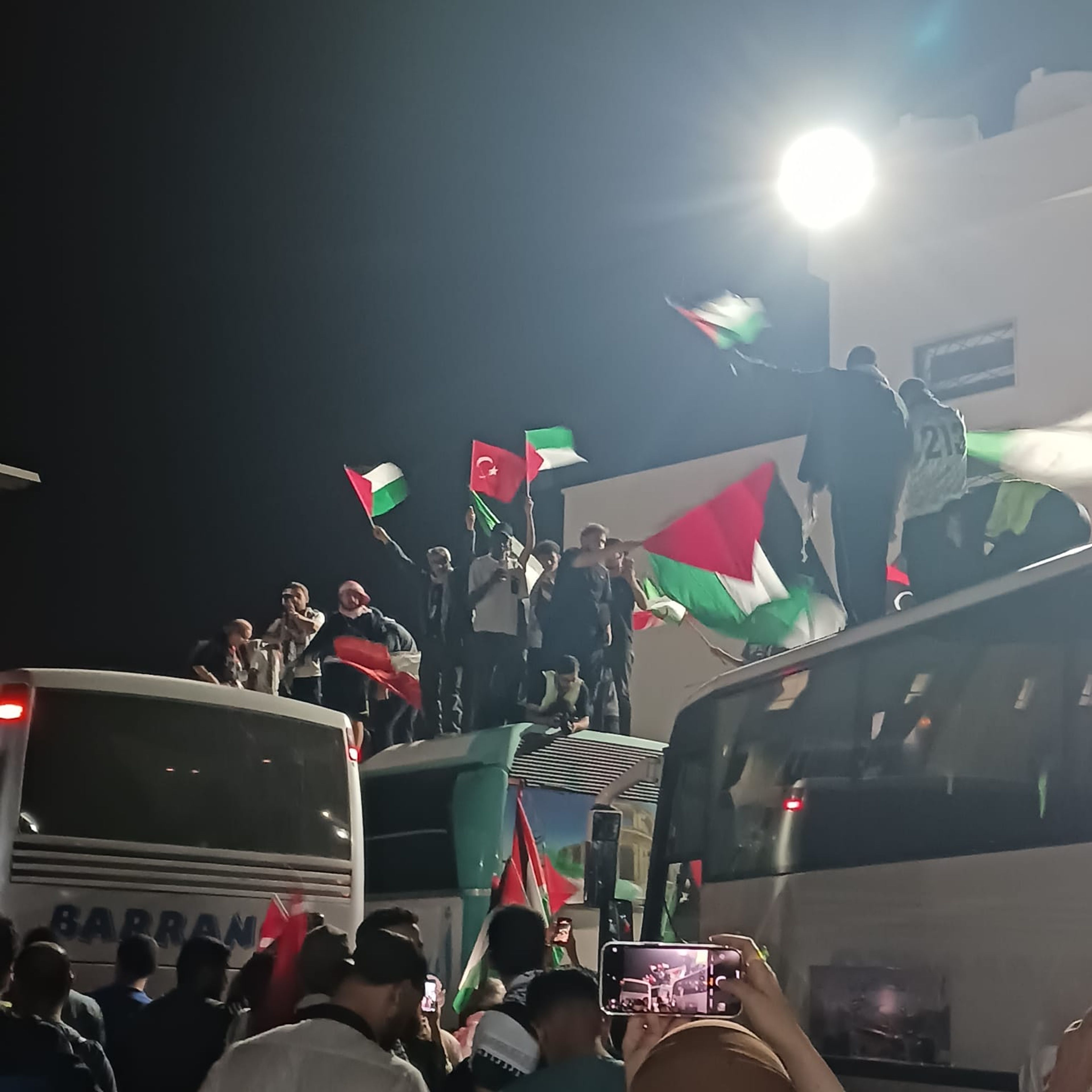 The Gaza Flotilla with participants waving the Palestinian flag at the Libya-Egypt border.