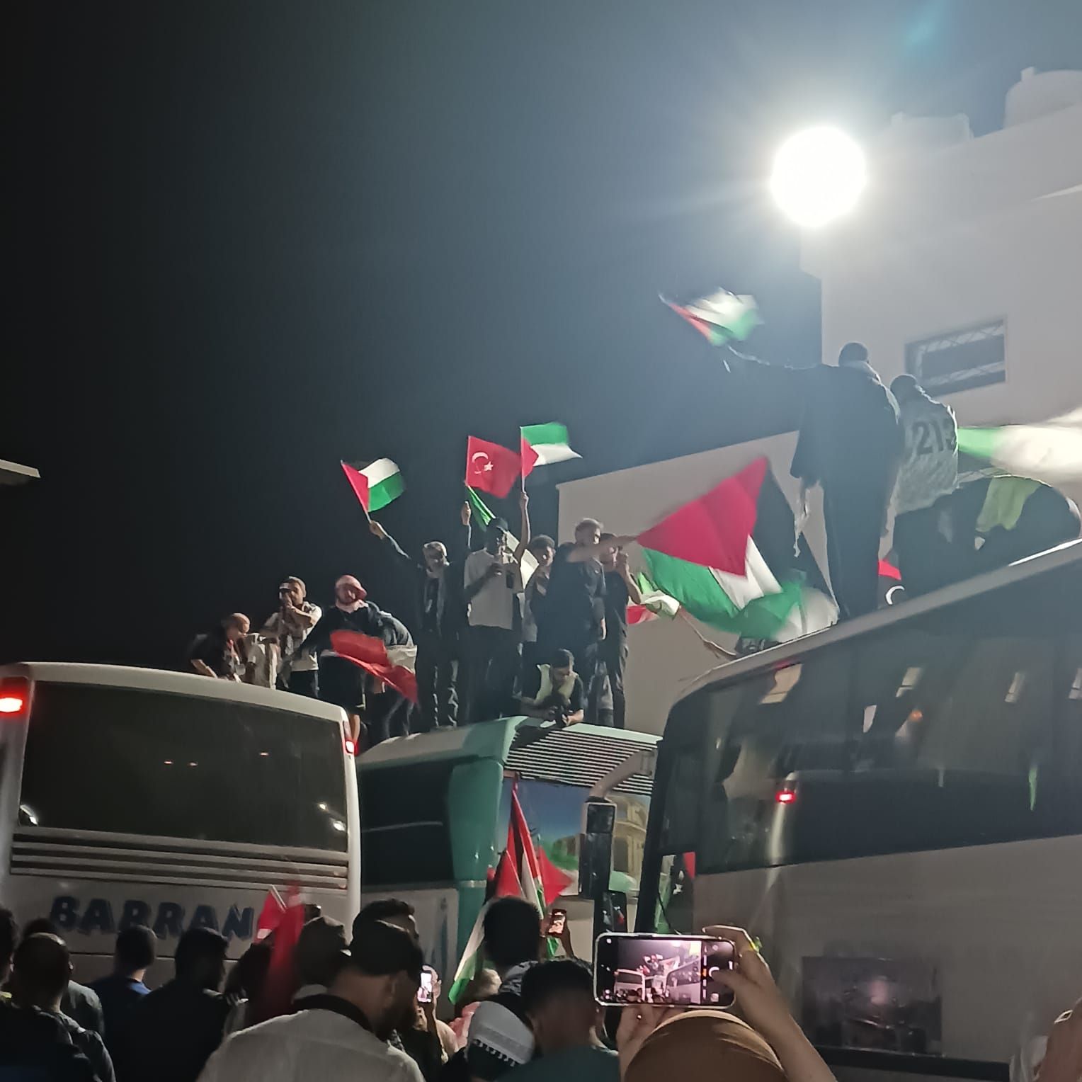 The Gaza Flotilla with participants waving the Palestinian flag at the Libya-Egypt border.