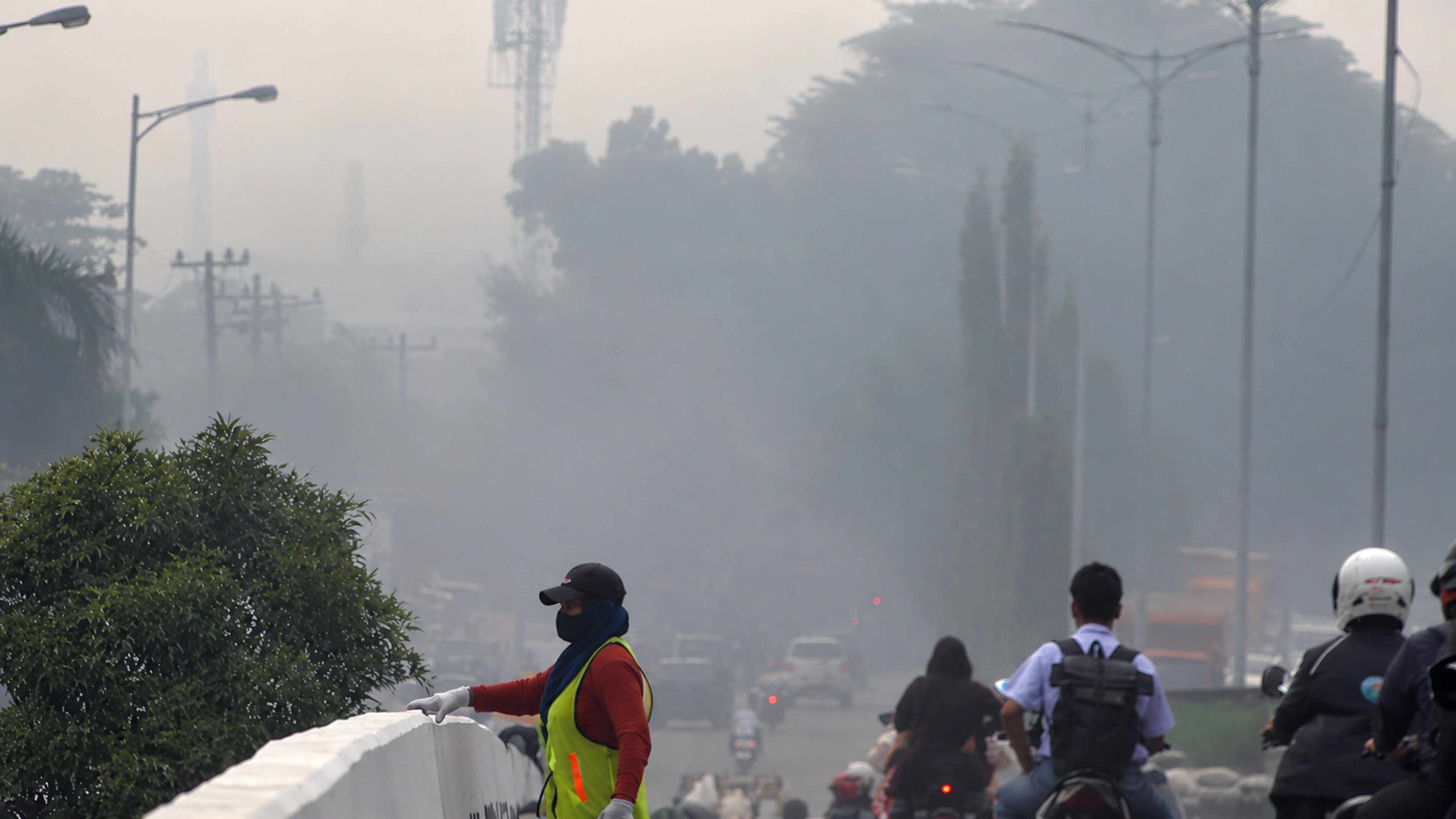A bridge cleaner wears a face mask as haze blankets Medan city, North Sumatra, Indonesia. Photo: Ahmidal Yauzar