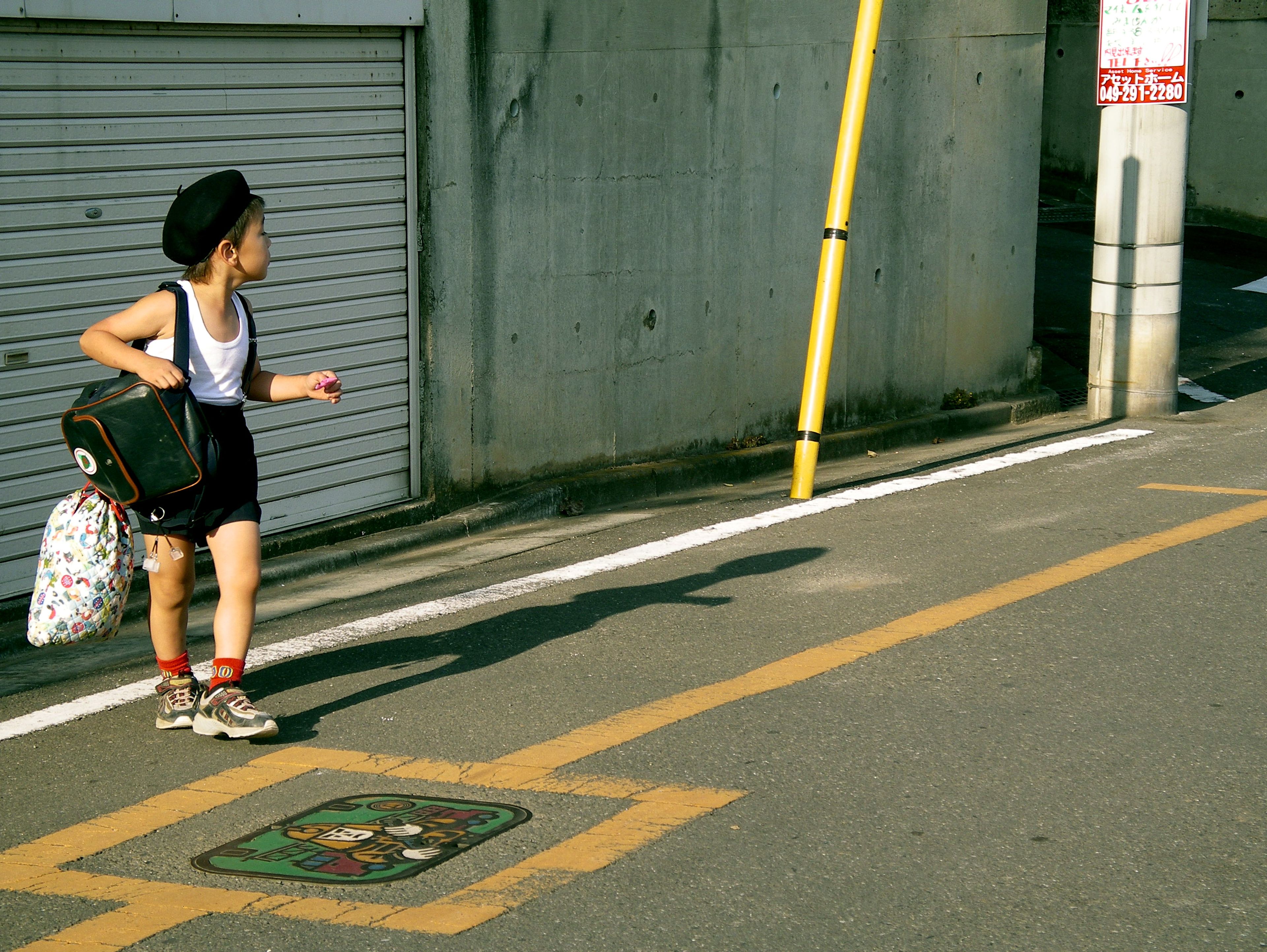 A Japanese schoolboy walks home along a street in Tsuruse, Japan, carrying his schoolbag after a day at school. The image offers a glimpse into the everyday routines of Japanese schoolchildren. Photo: Jenny Webber/Wikimedia Commons (CC BY-SA).