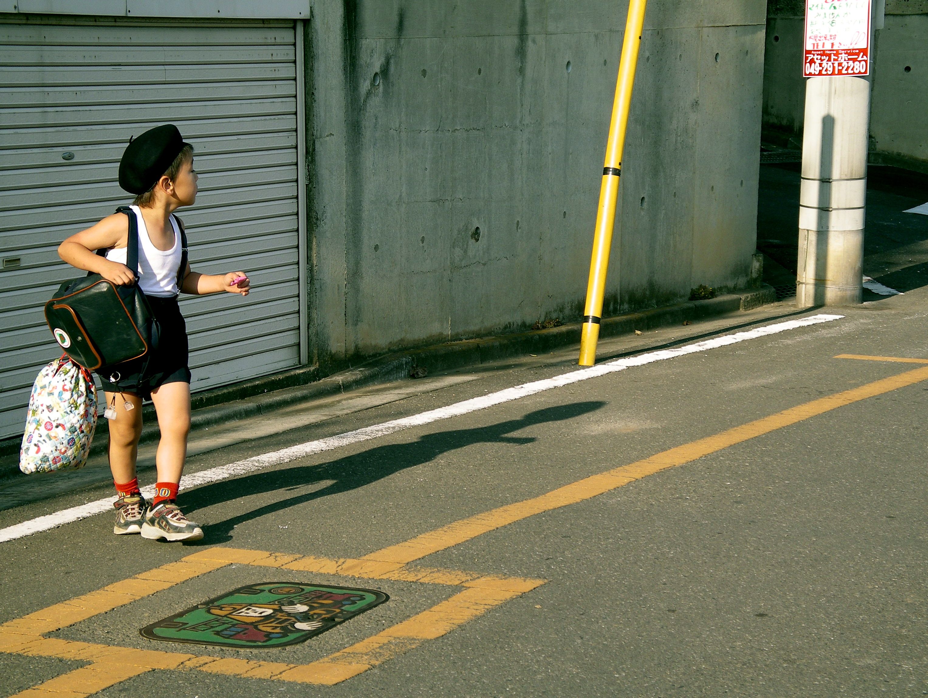 A Japanese schoolboy walks home along a street in Tsuruse, Japan, carrying his schoolbag after a day at school. The image offers a glimpse into the everyday routines of Japanese schoolchildren. Photo: Jenny Webber/Wikimedia Commons (CC BY-SA).