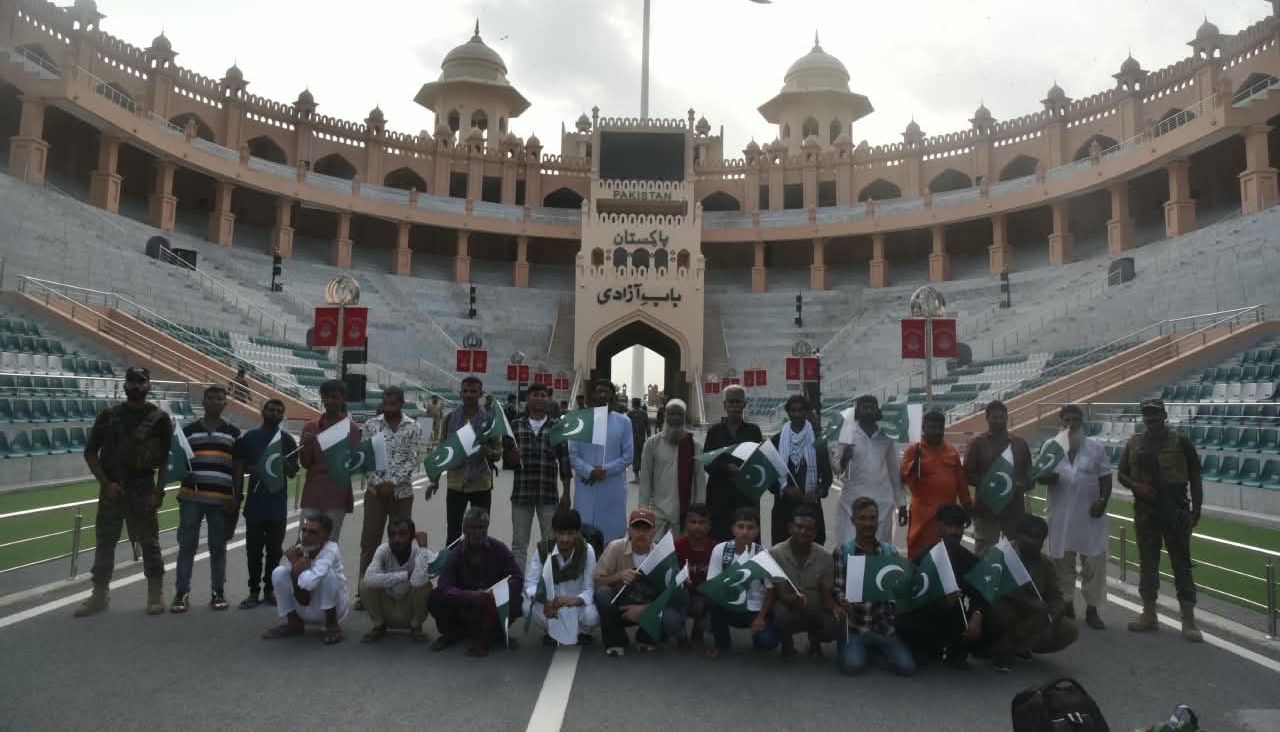 Twenty-five Pakistani nationals pose with Pakistani flags after being repatriated through the Wagah-Attari border. Officials from the Pakistan High Commission in New Delhi were present to facilitate the process.