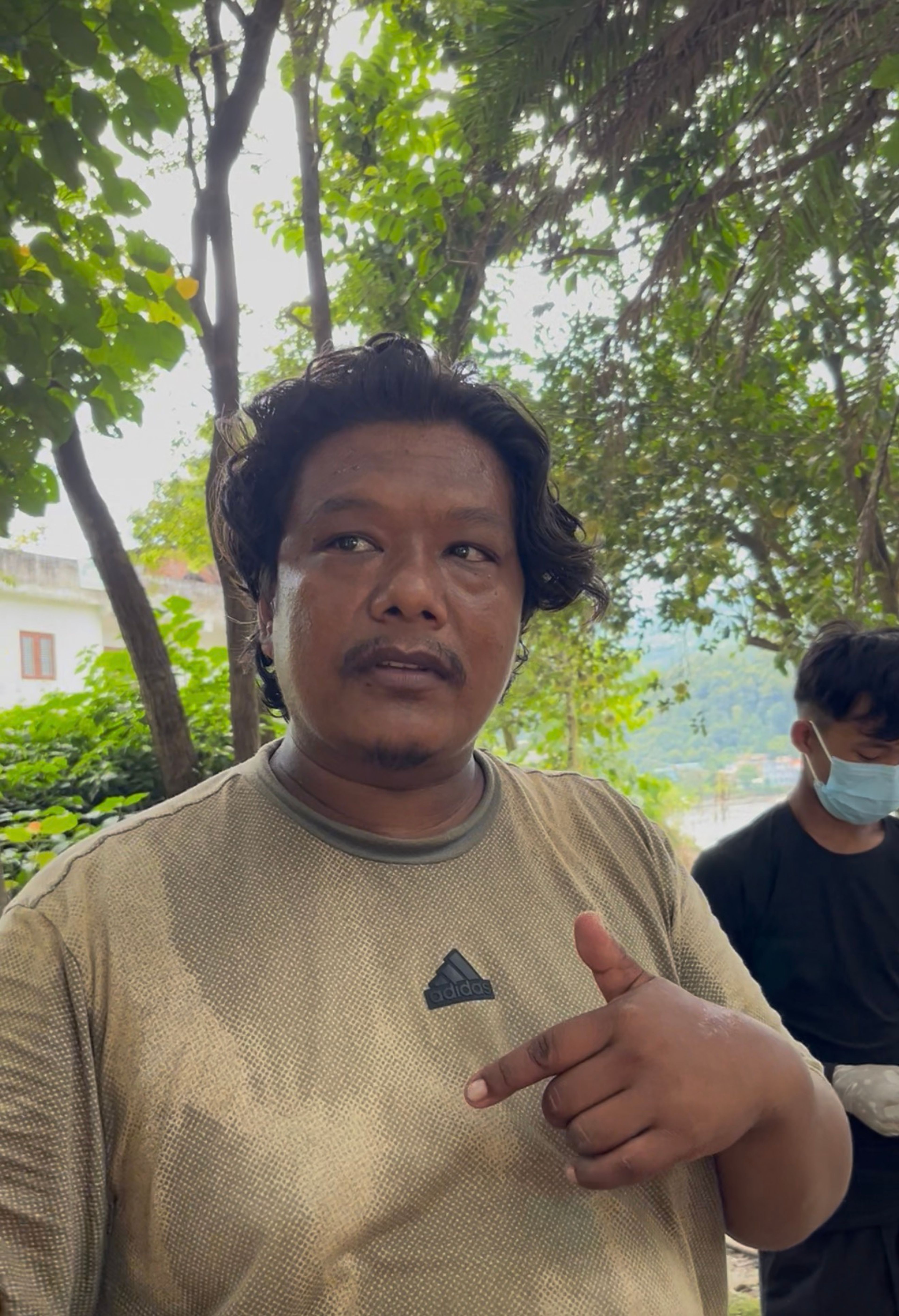 A member of a relief team Milan Shrestha stands near the flood-affected area in Betrawati town, Rasuwa district, Nepal, during relief operations following flooding along the Trishuli River. Photo: Yogesh Nepal