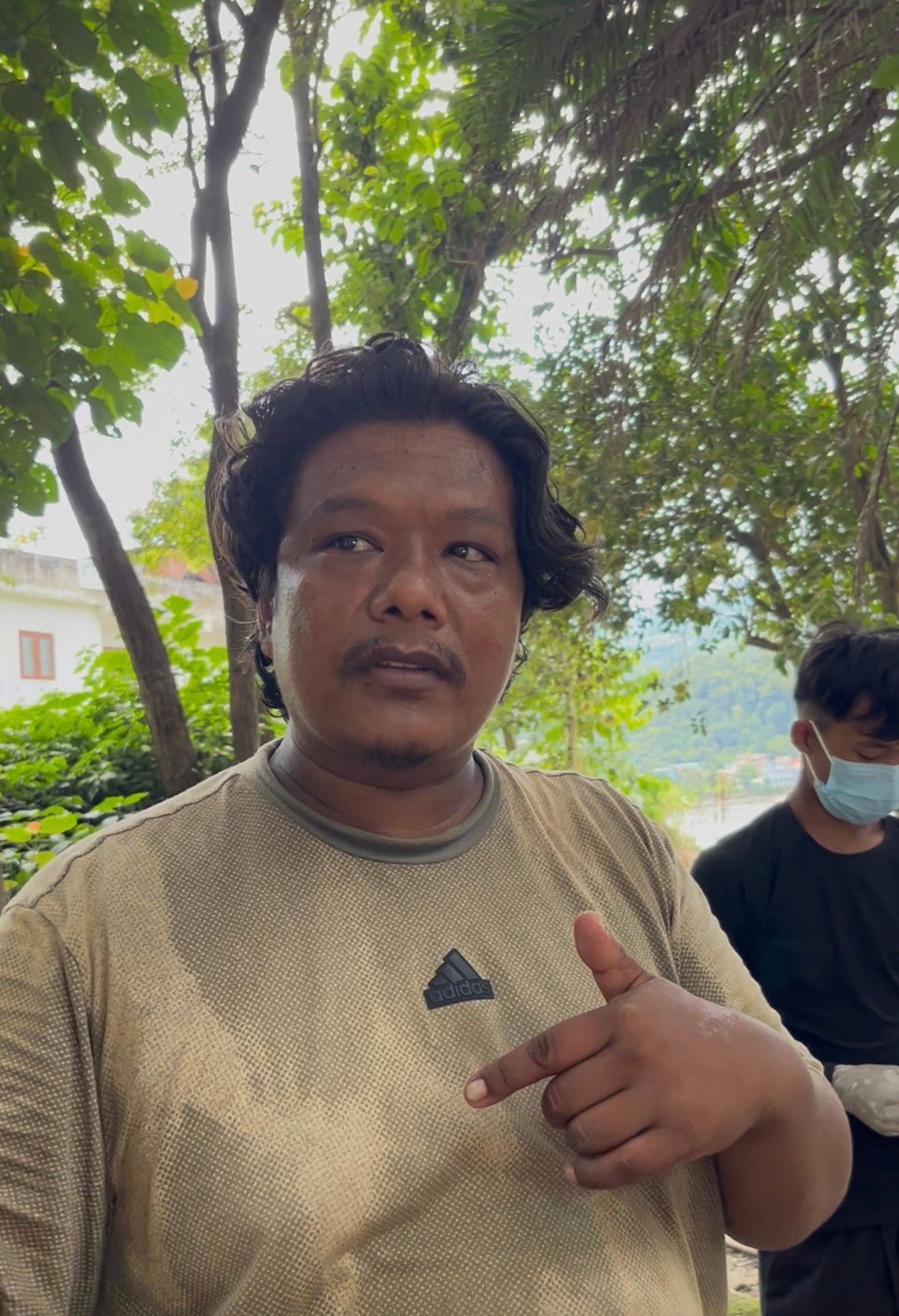 A member of a relief team Milan Shrestha stands near the flood-affected area in Betrawati town, Rasuwa district, Nepal, during relief operations following flooding along the Trishuli River. Photo: Yogesh Nepal