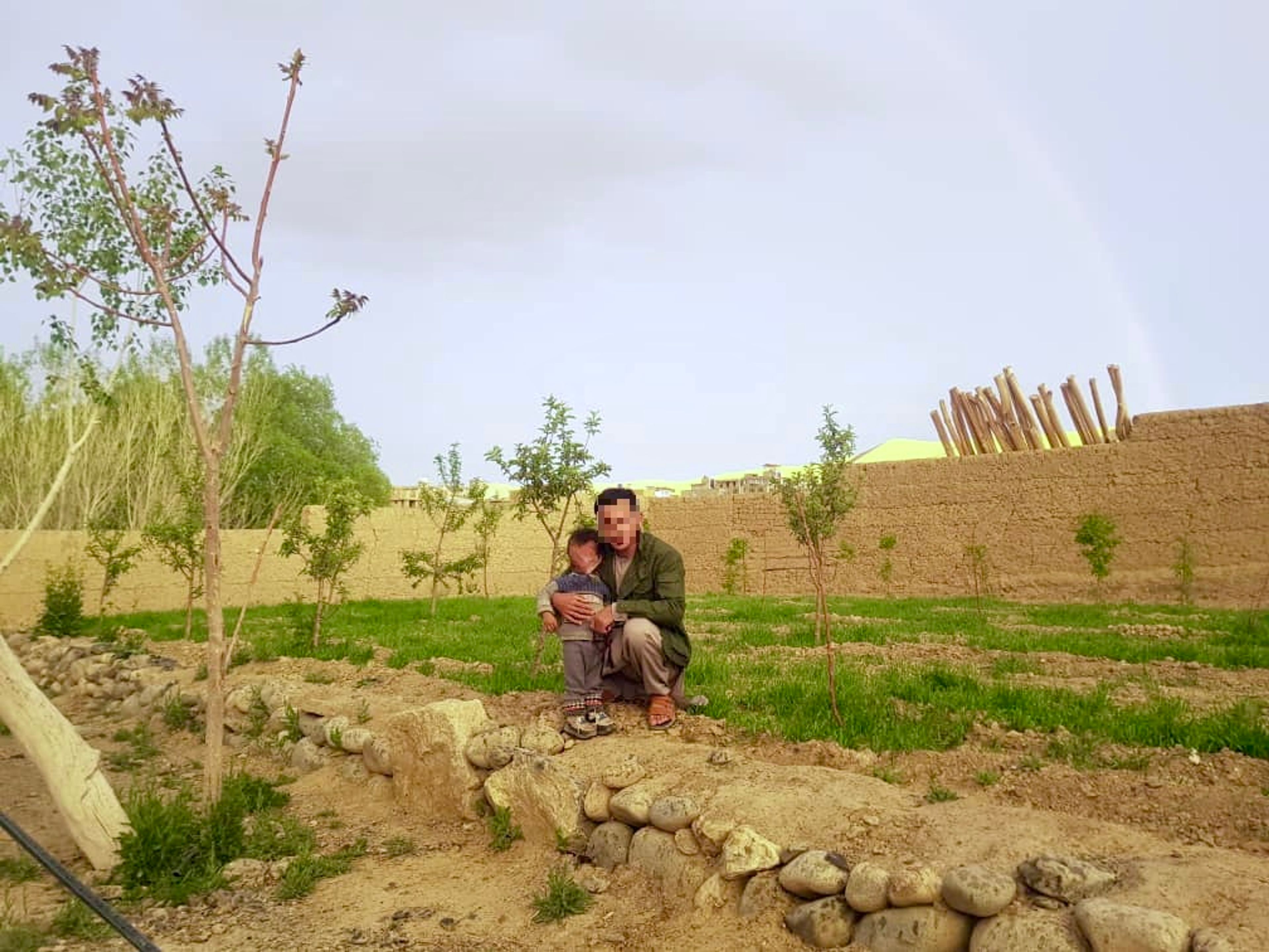 Husaini poses with his two-year-old child in Bamyan Province, Afghanistan, before leaving to join the Fatemiyoun Brigade in Syria.