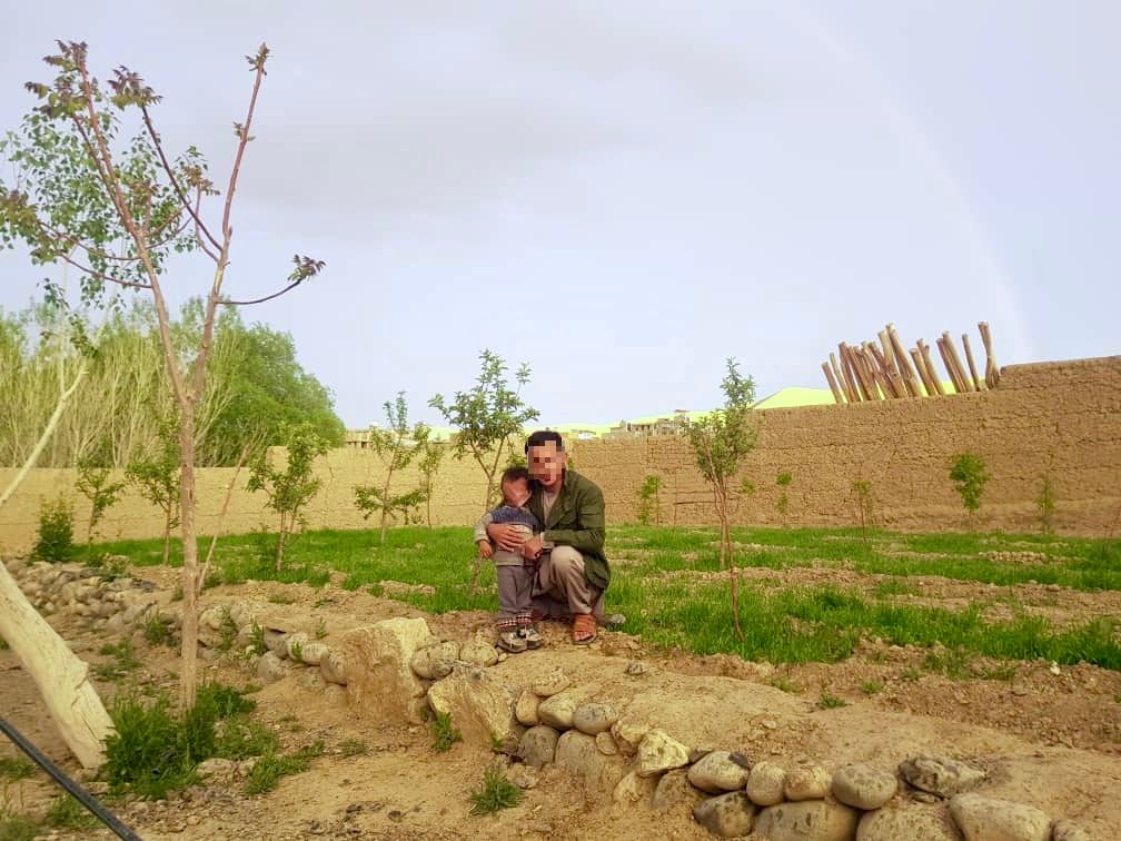 Husaini poses with his two-year-old child in Bamyan Province, Afghanistan, before leaving to join the Fatemiyoun Brigade in Syria.