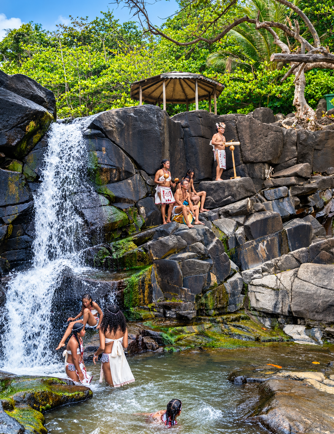 A group of Kalinago cultural dancers gathers at the sacred Isulukati Waterfall in Dominica, celebrating their connection to nature and ancestral traditions. Photo: Discover Dominica Authority.