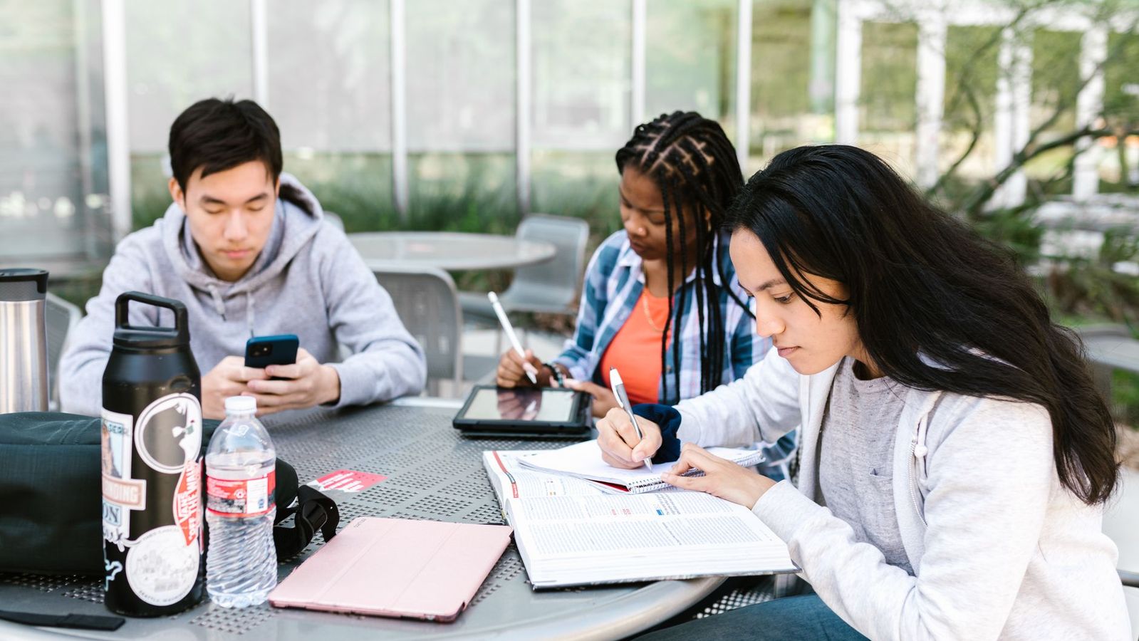 College students sharing a sunny apartment rooftop study space near USC